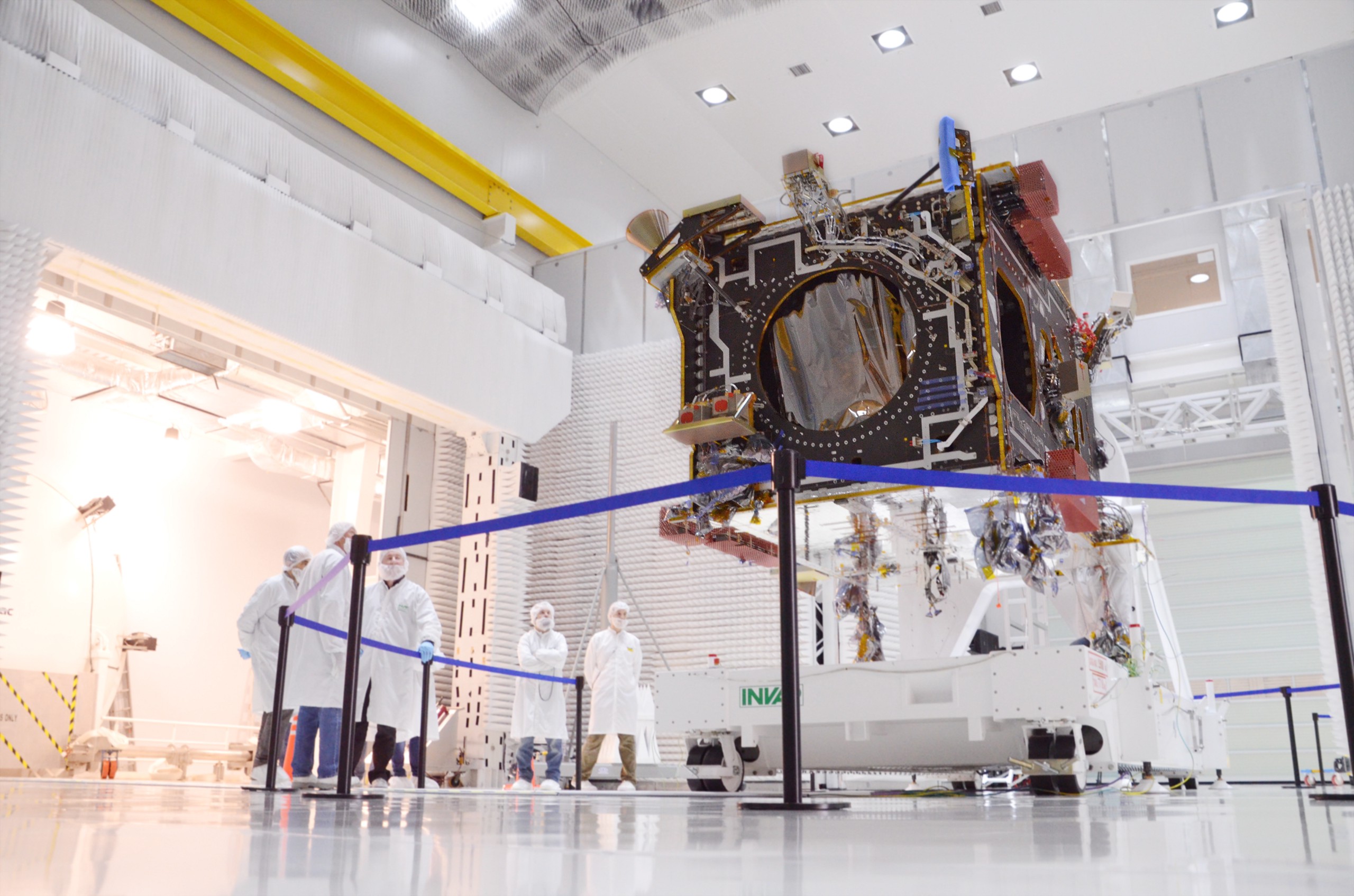 Workers stand around a satellite in the middle of INVAP's clean room.