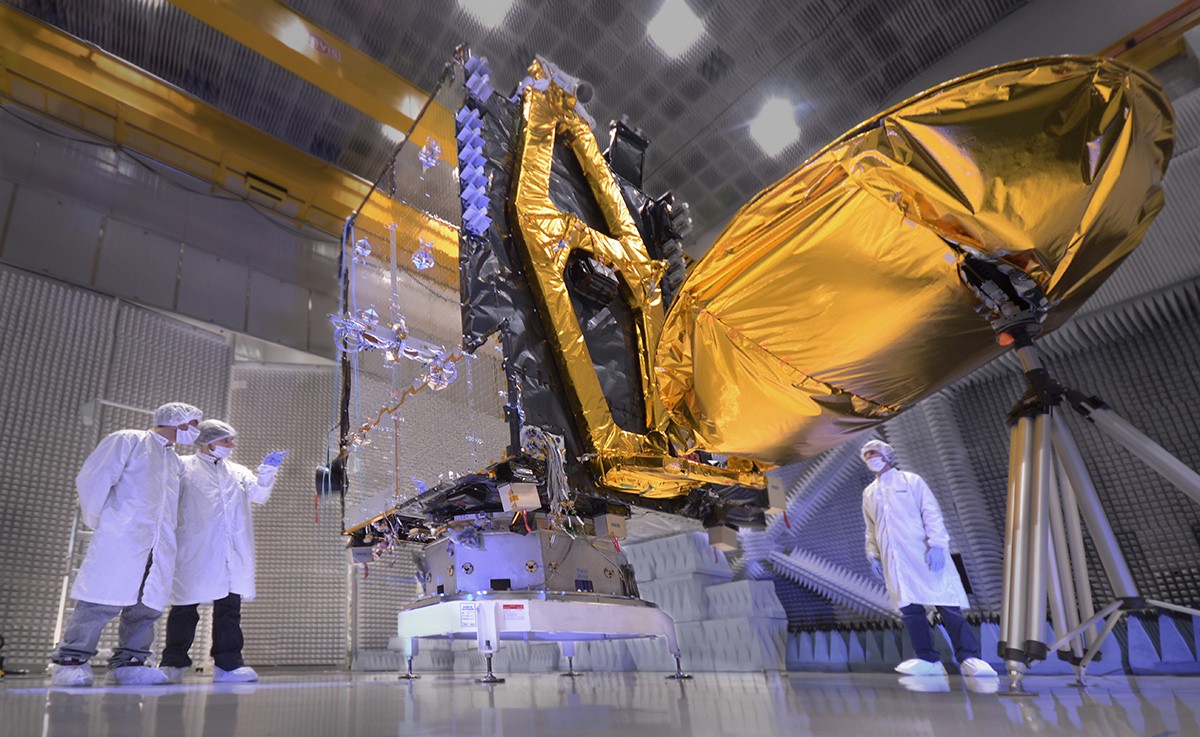 Workers stand around a satellite in INVAP's clean room.