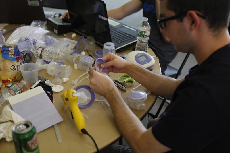A man works on a plastic breast pump model concept.