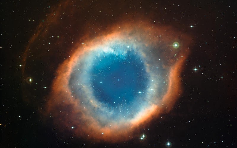 A blue gas cloud around a star, with an orange rim around the cloud.