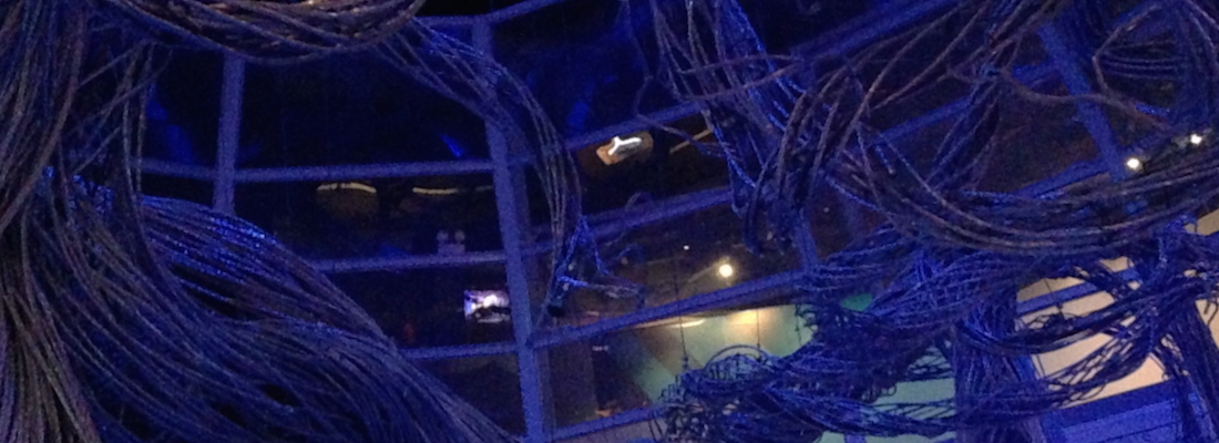 A large tangled mass of cables runs around the interior structure of a building.