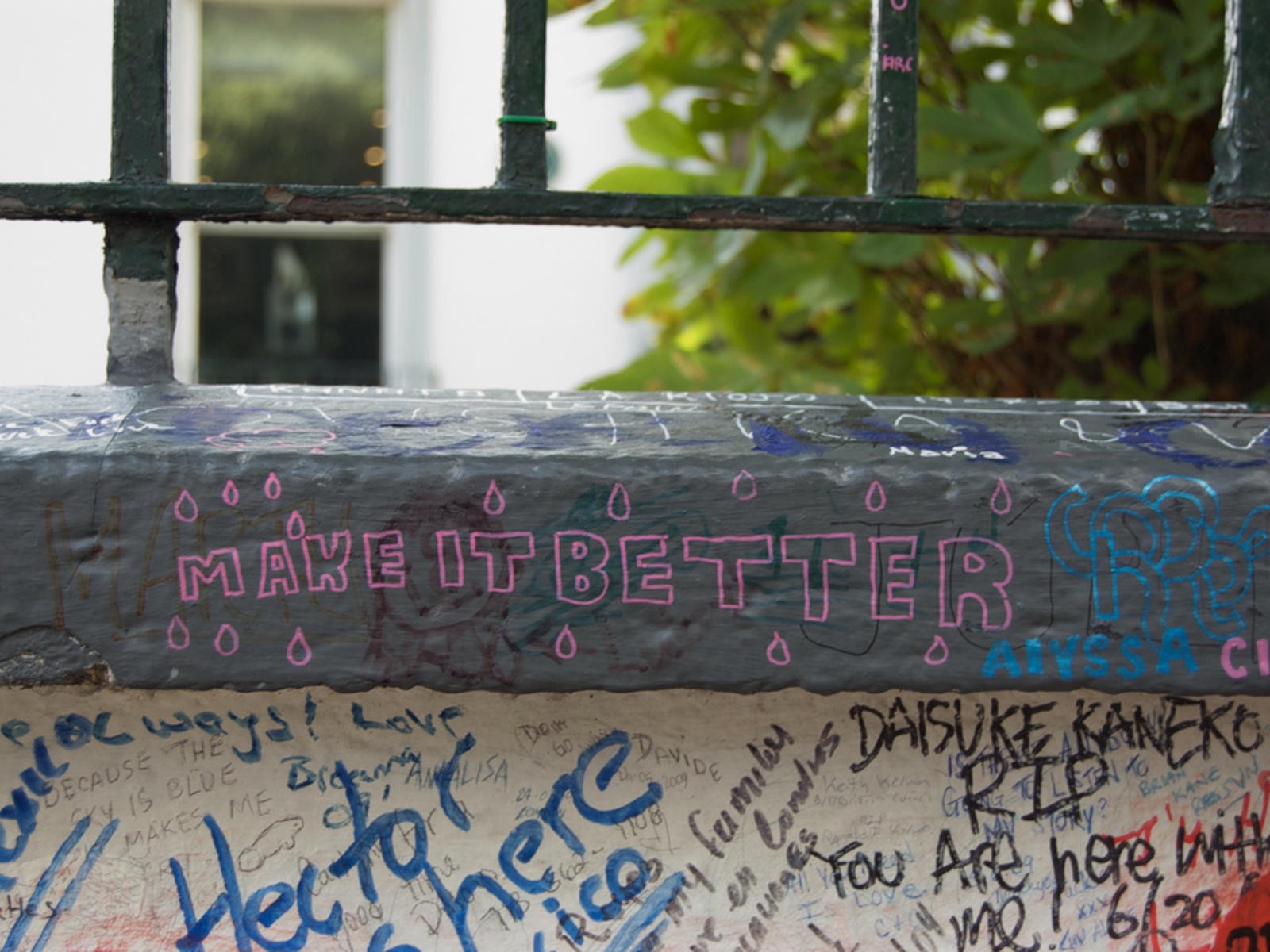 Graffiti on a wall. The most prominent graffiti reads "MAKE IT BETTER."