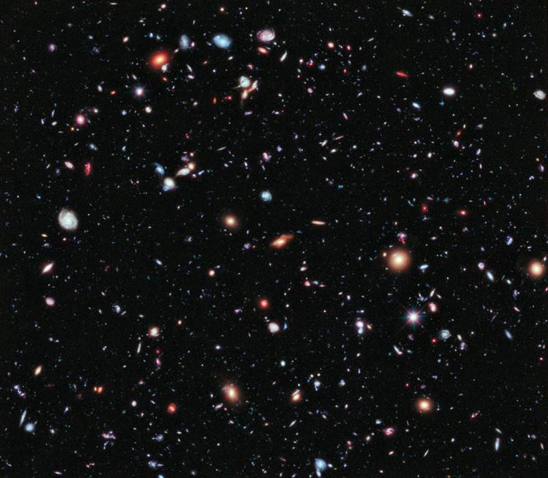 Innumerable small galaxies, the size of stars, in a square image of black sky.