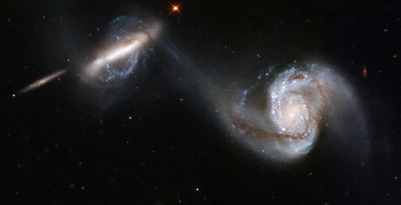A pair of two-armed spiral galaxies, with the arm of one being sucked out towards the other galaxy.