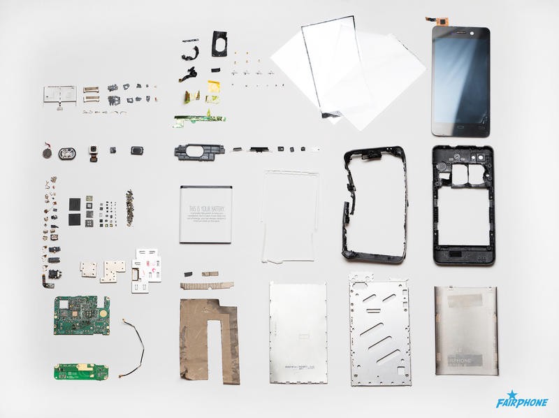 The disassembled components of a smartphone laid out on a table.