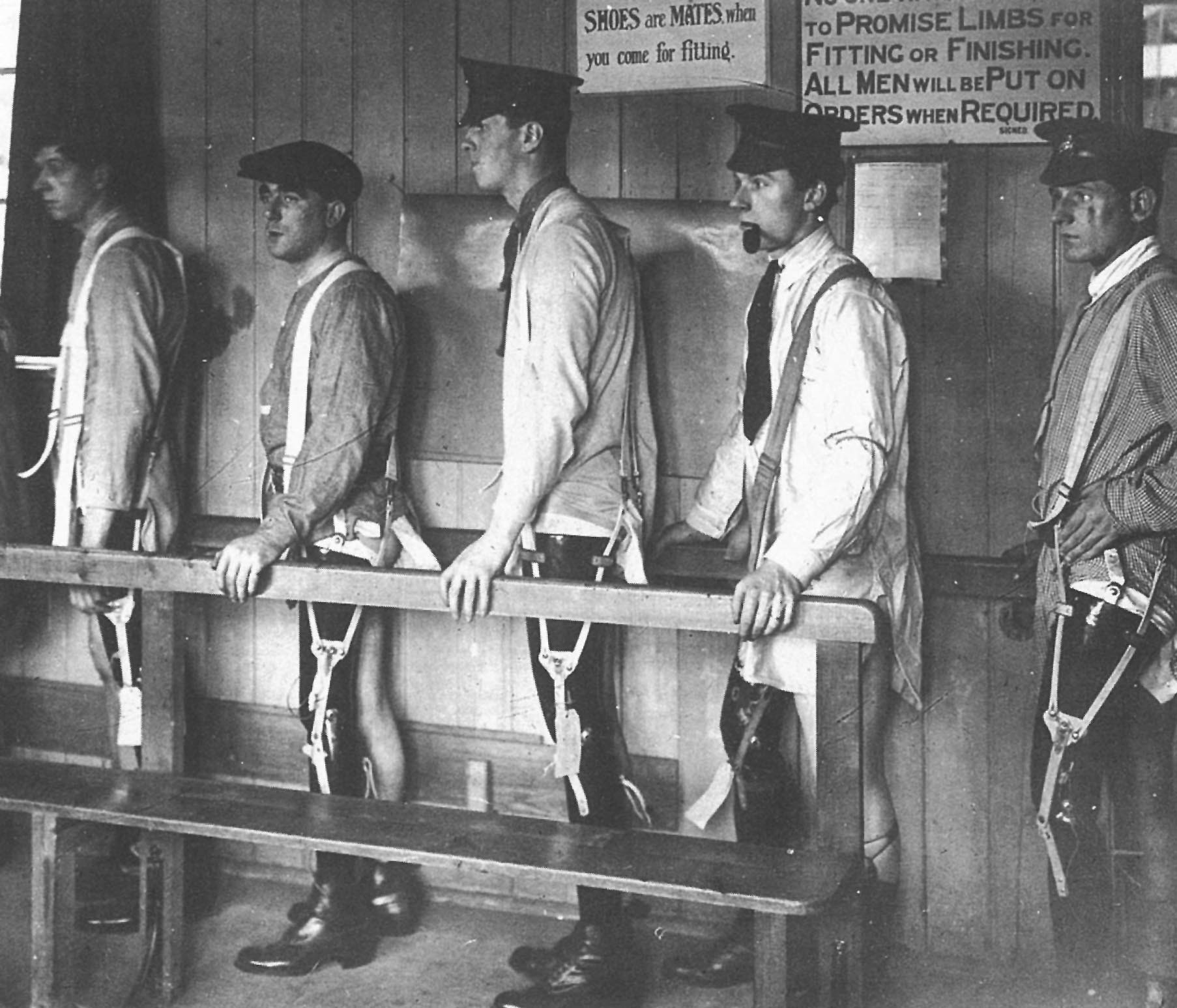 A row of men in army caps line up, each wearing a prosthetic leg.