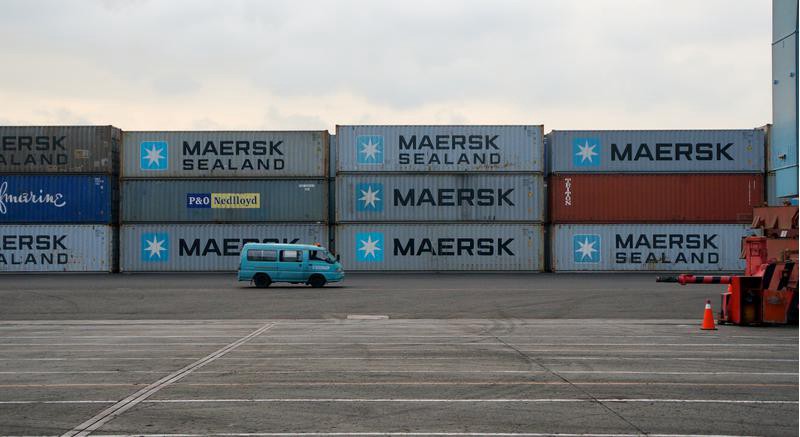Maersk containers stacked on the tarmac at the port.