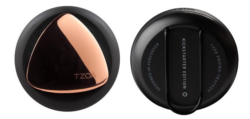 Examples of the wearable sensors that detect air quality. Black circular devices with a bronze plate on one side, with a plastic clip on the other.