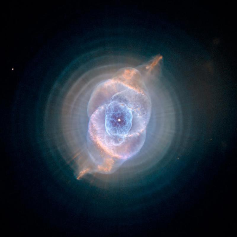 An exploding nebula. The central explosion is bright blue, with the outer clouds a kind of reddish-yellow-brown.