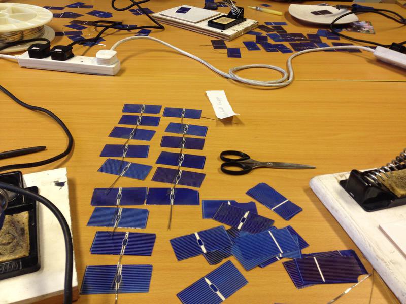 Solar cells laid out in rows on a table.