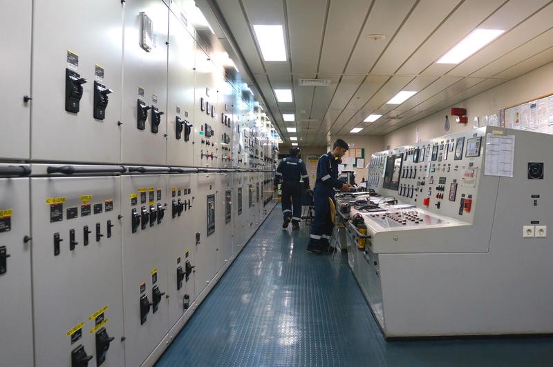 A long room with operational equipment, computers, dials, etc., in the engineering control room.