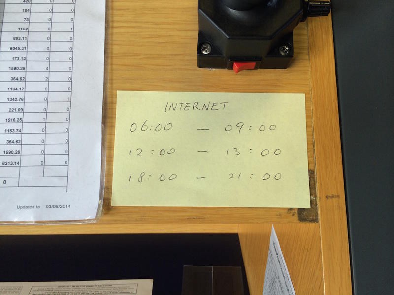 A post-it note on a desk reads:
INTERNET
06:00-09:00
12:00-13:00
18:00-21:00