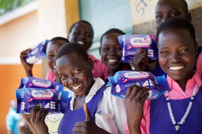 A group of young girls holding AFRIpads kits.