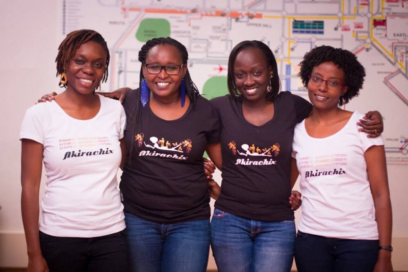 A line of women pose for the camera, smiling. They are wearing Akirachix t-shirts.