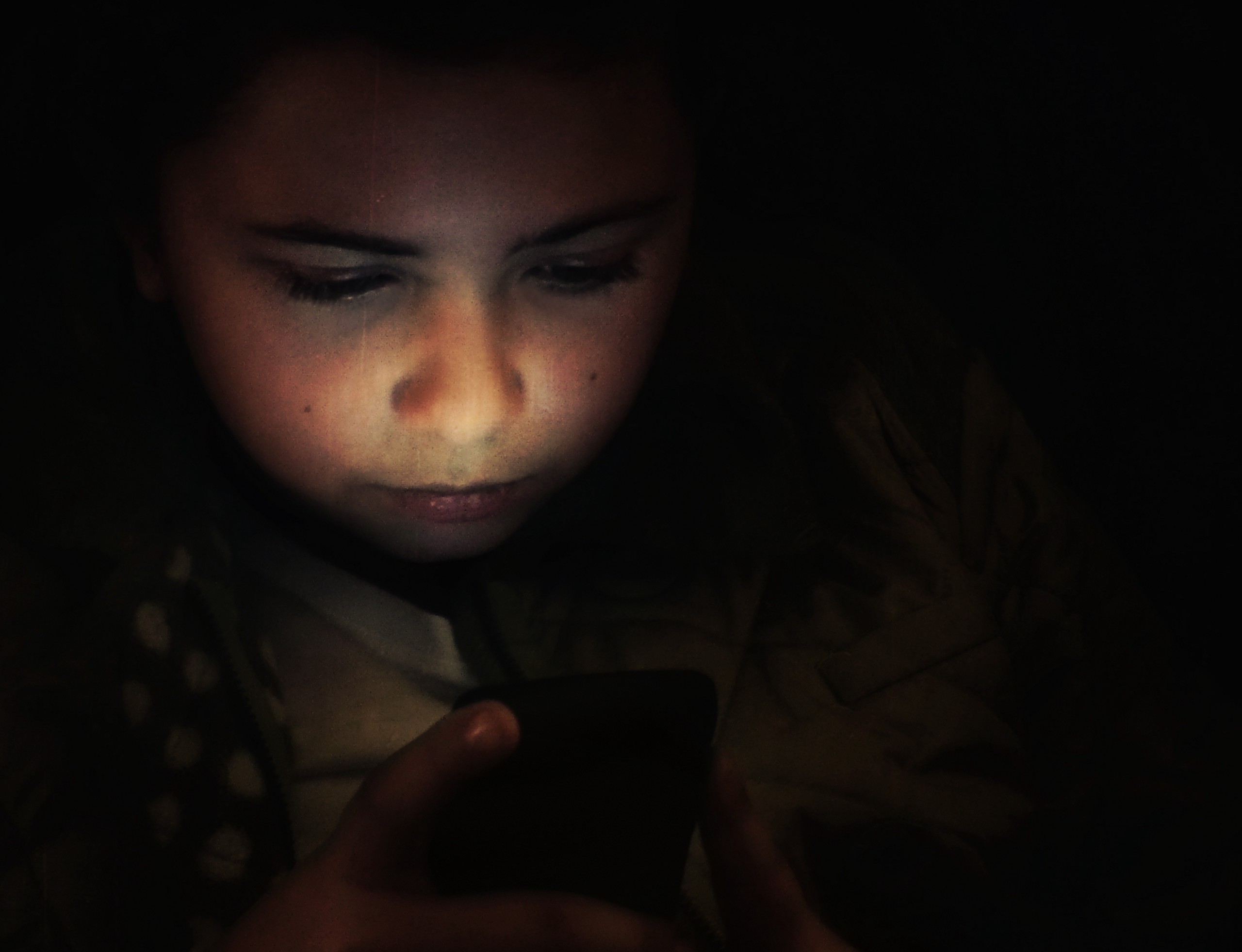 A girl plays on a smartphone.