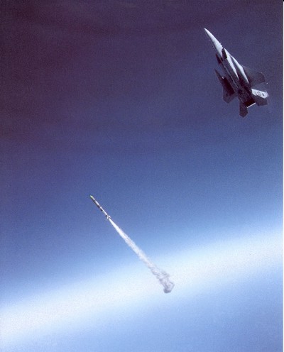 A jet fighter swoops away from a just-fired missile that is heading up out of the atmosphere.