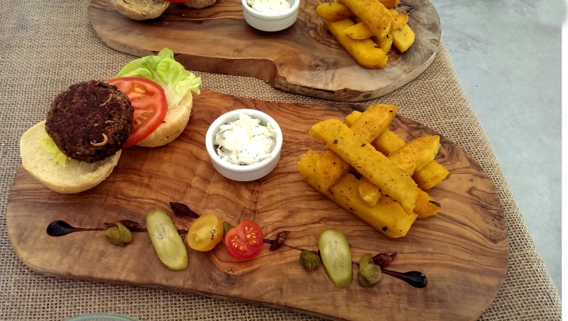 Wooden boards with bug burgers and fries on them.