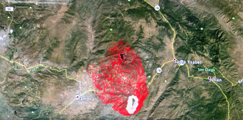 A satellite view of a mountainous area, with areas at risk of wildfire highlighted in red.