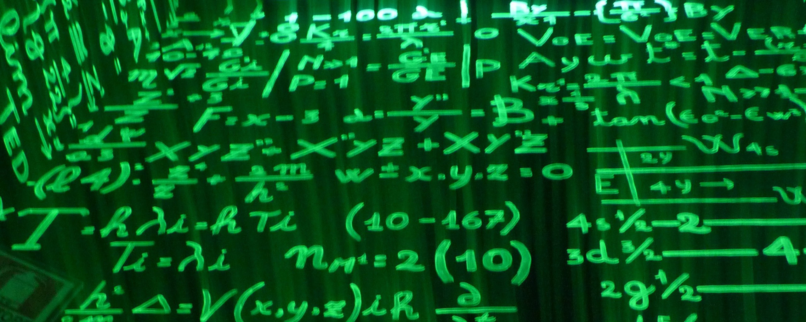 Green written equations on a blackboard.