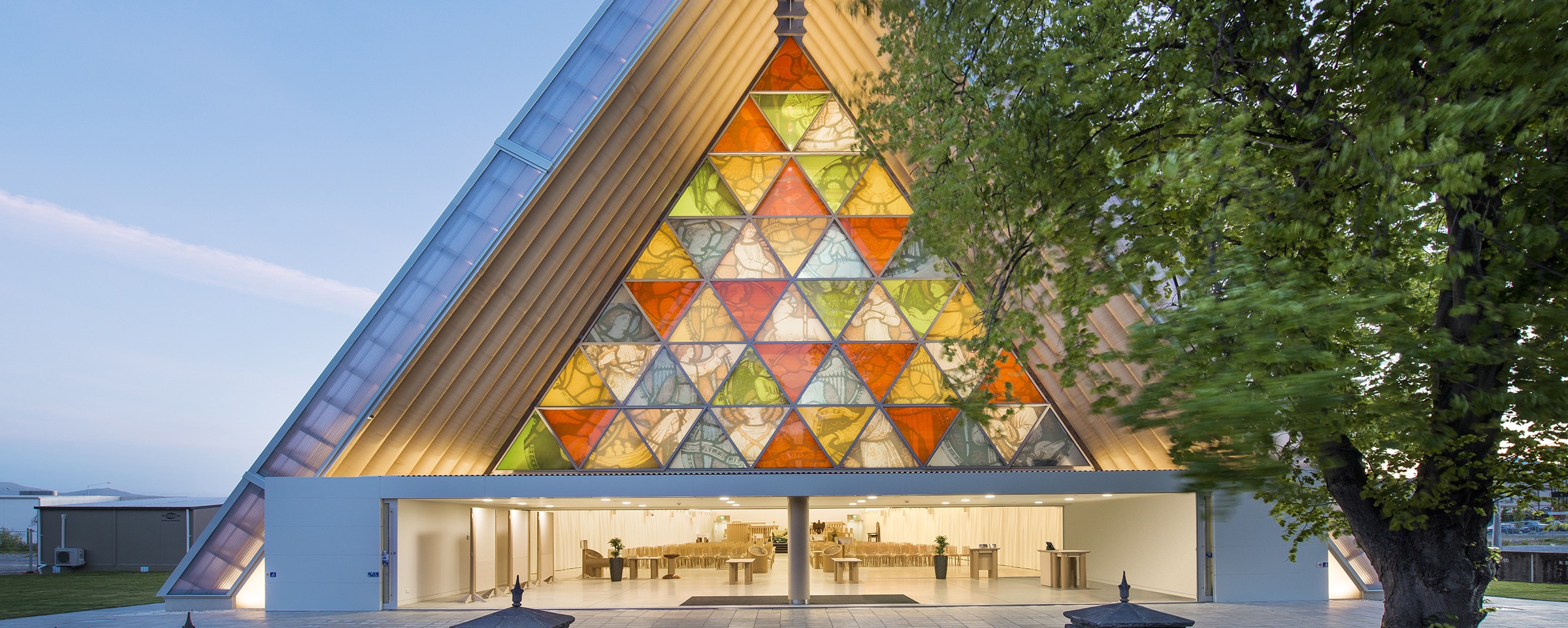 The Cardboard Cathedral in Christchurch, NZ. A triangular building with a large wall of stained glass.
