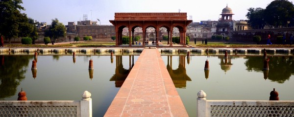 A ceremonial arch flanked by decorative ponds, part of a palace-type setting.