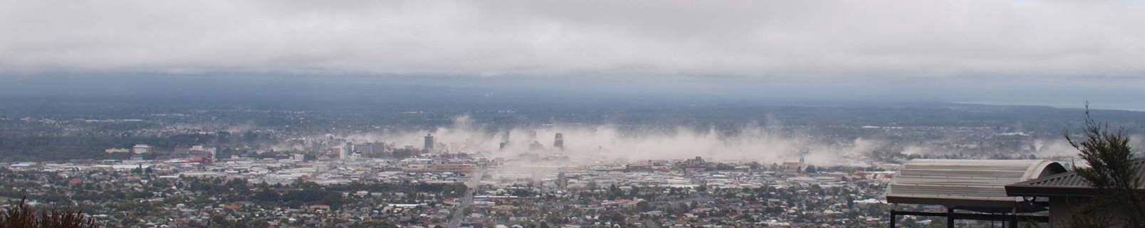 A view of the Christchurch city skyline, with large clouds of dust obscuring the central areas.