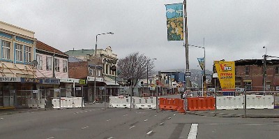 A closed-off street with damaged buildings either side.