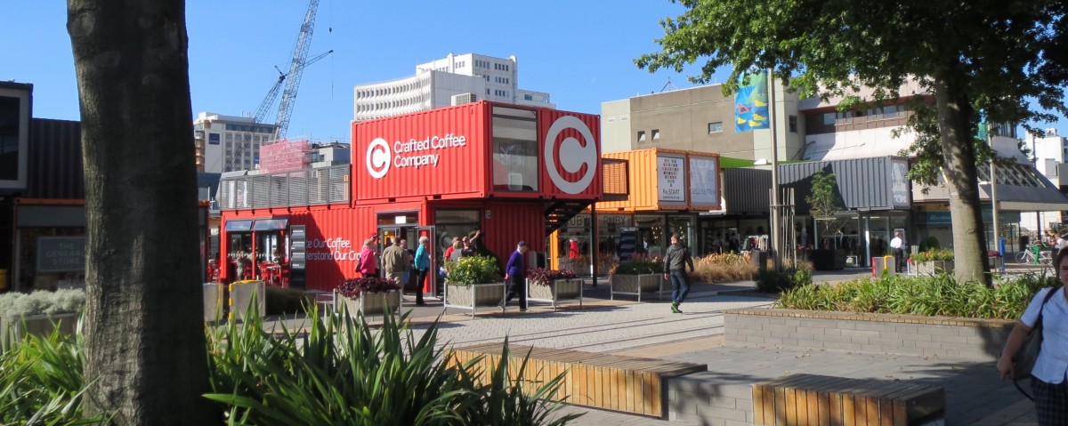 A number of small stores based in converted shipping containers around a small square.