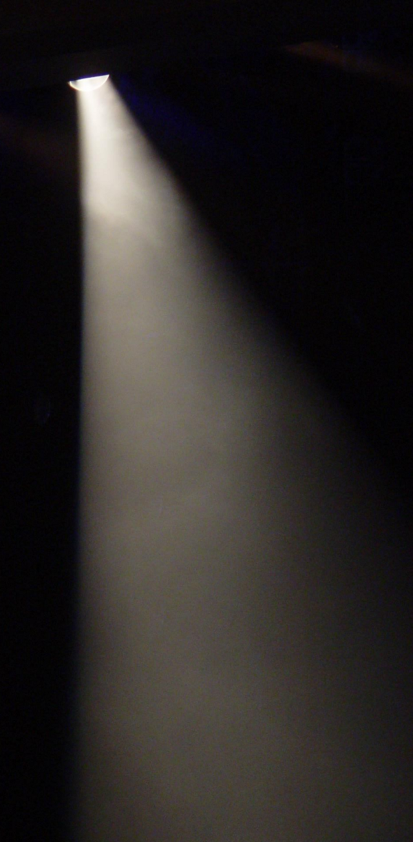 A spotlight beaming down in a dark room.