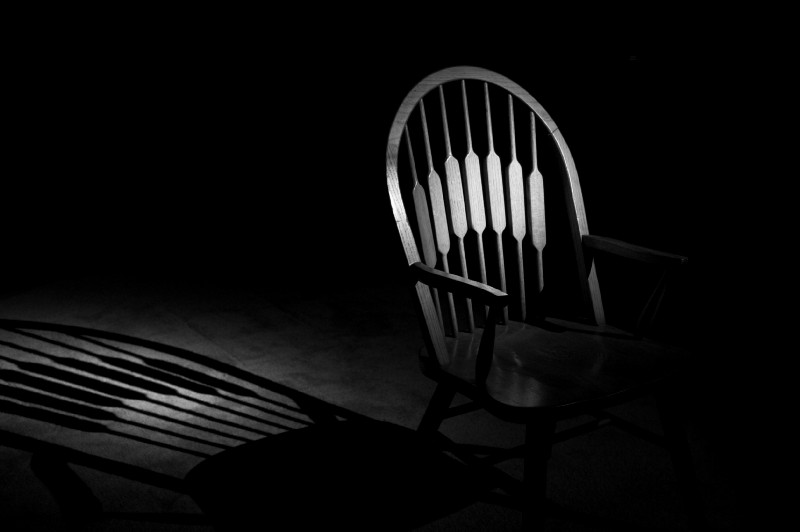 A chair in a dark room.