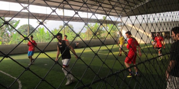 Soccer game viewed from behind a chain-link fence