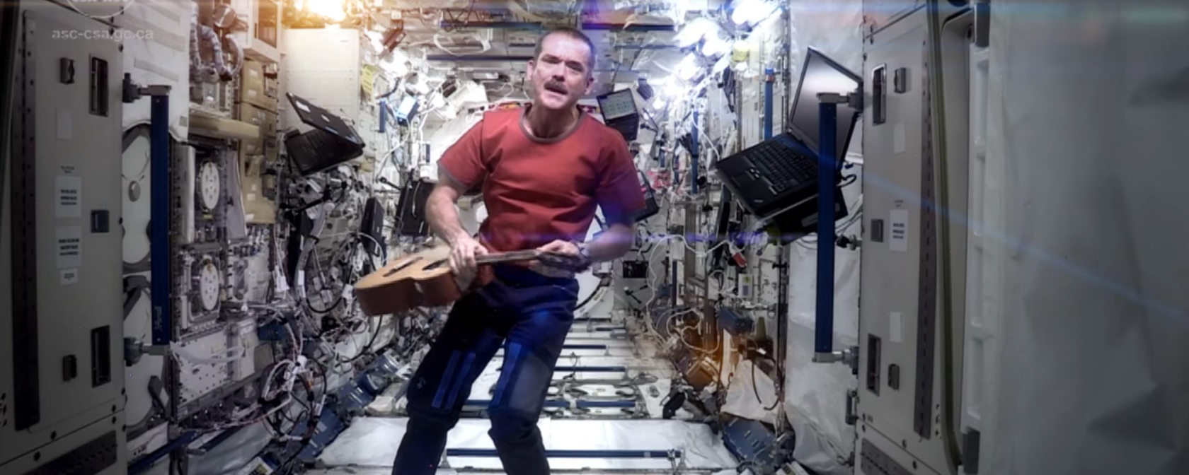 Astronaut Chris Hadfield holds a guitar while floating on the ISS.