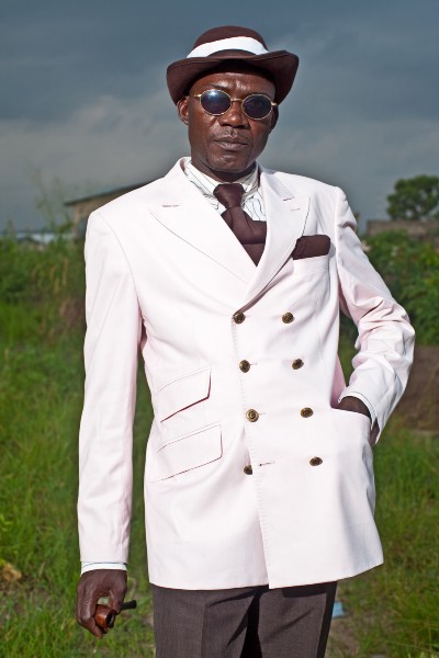 A black man in a white double-breasted blazer.