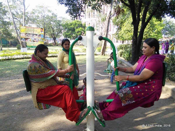 Women in India play on a roundabout.