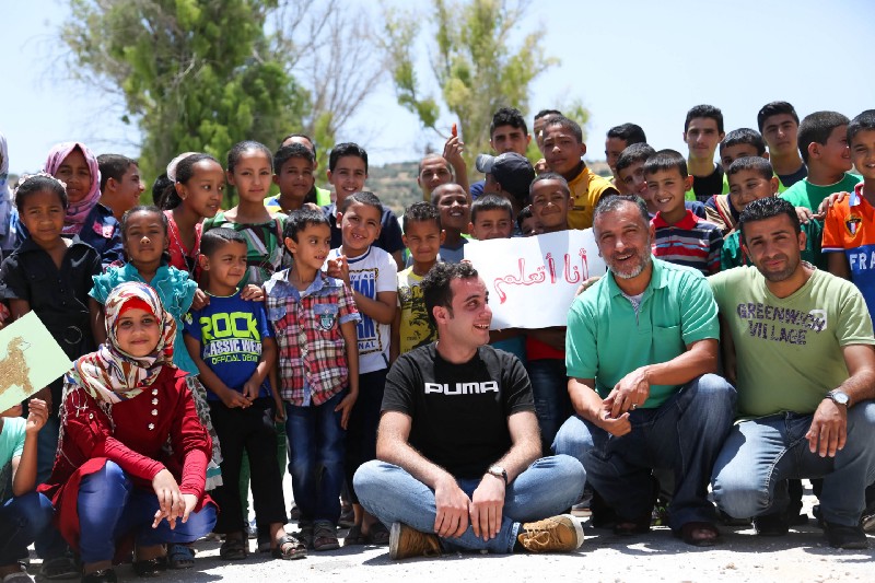 The employees of I Learn pose for a photo with a class of young children.
