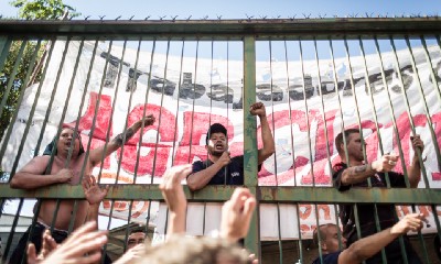 Protesters climbing a fence.