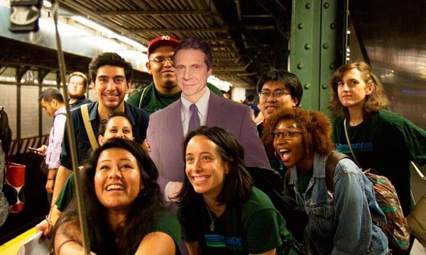 Activists pose with a cardboard cutout of New York governor Cuomo.