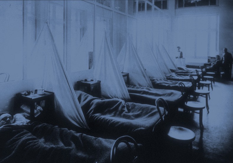 Patients in a row of beds in an infirmary