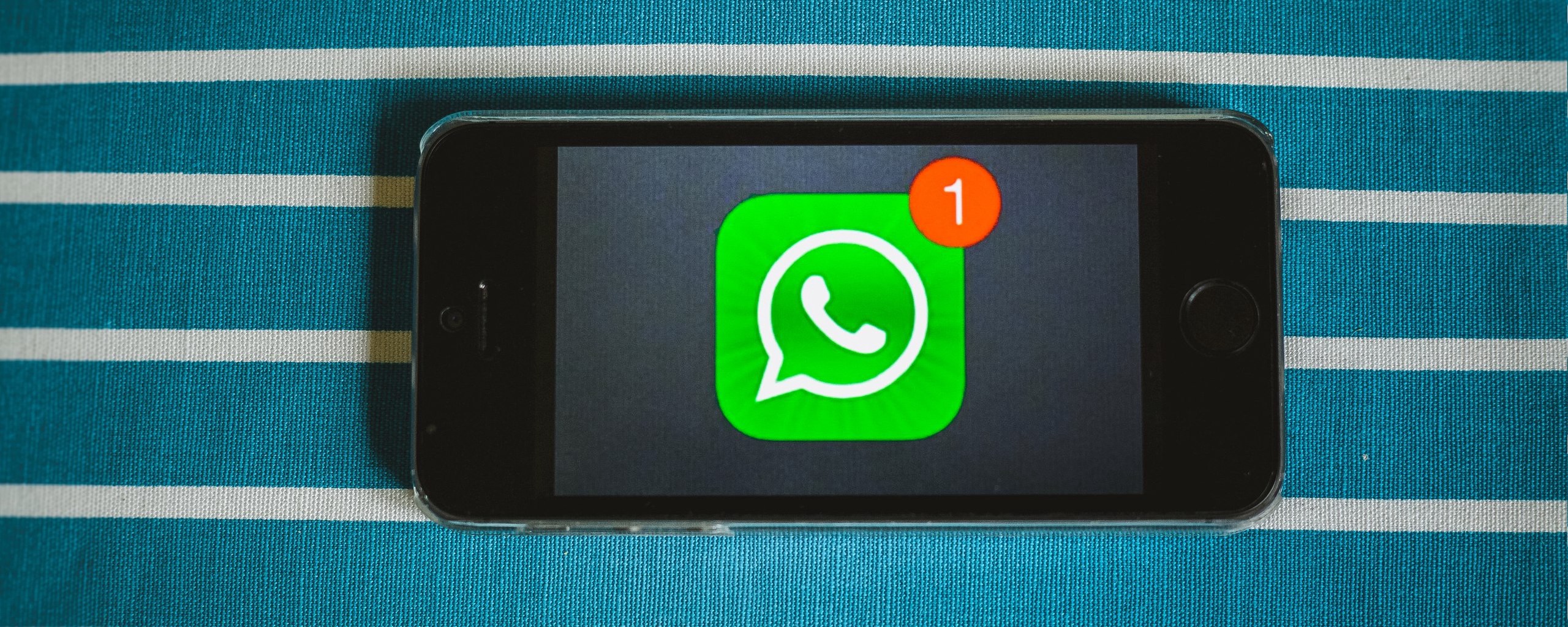 Mobile phone showing the WhatsApp logo with one notification