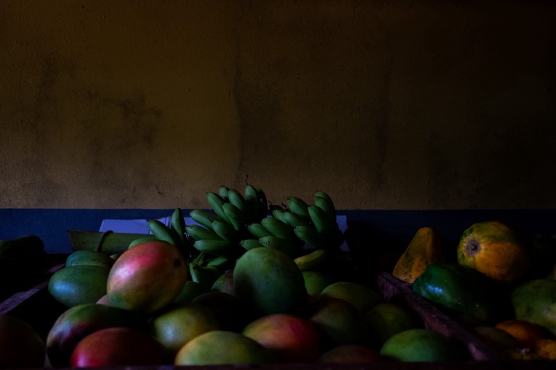 A pile of fruit on a table in a room.