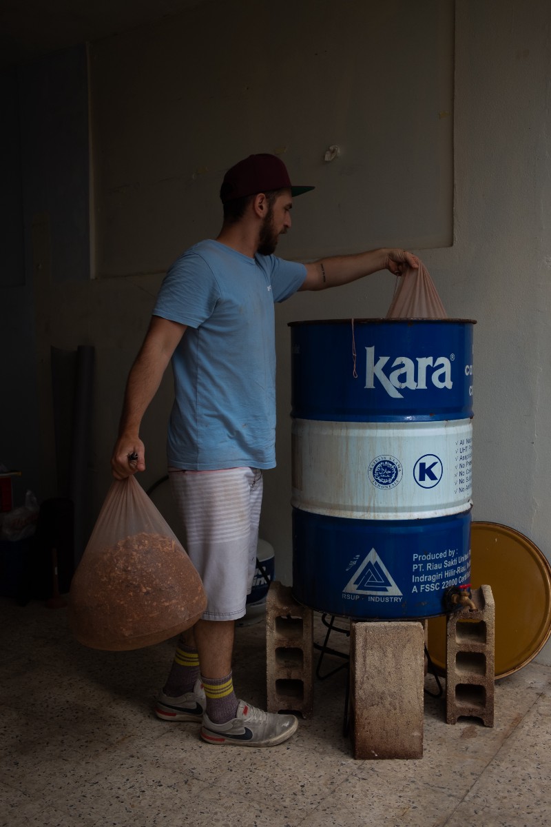 SebastiÃ¡n Sagardia putting a bag of wood chips in a large metal drum
