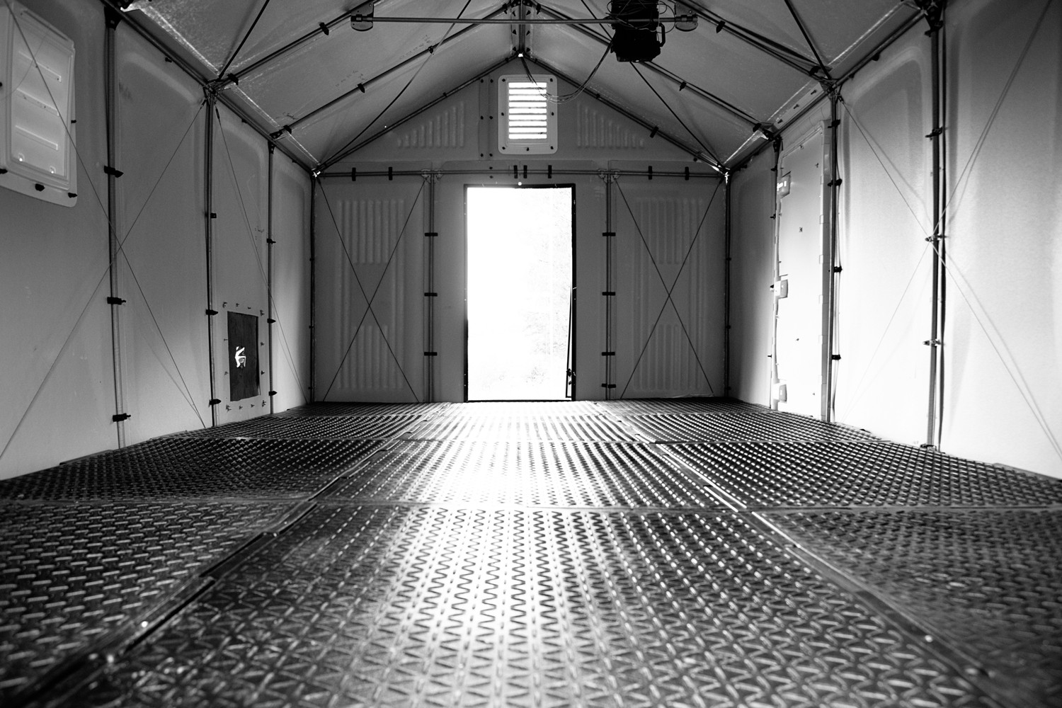 An empty demonstration tent with a metal floor.