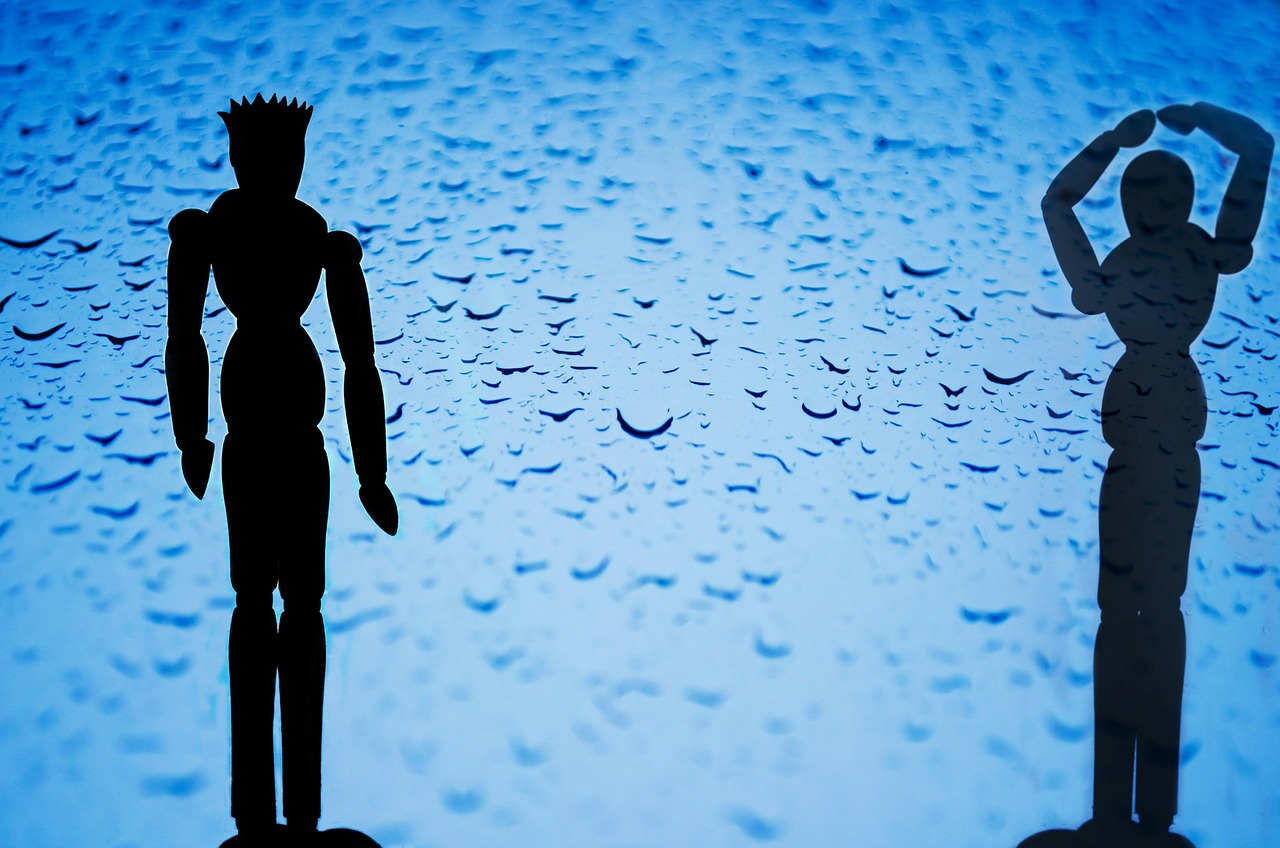 Two figures, mannequins, silhouetted against raindrops on a window.